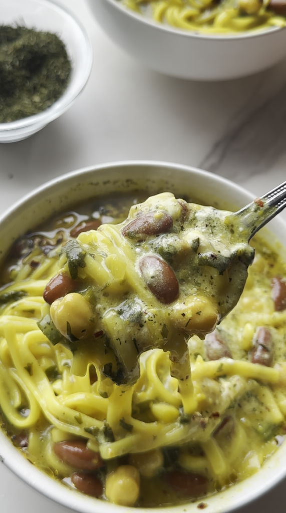 a bowl of aush/ash reshteh and a spoon of it in front of the camera